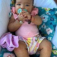 Sofia is registered to the contest to win money with this photo: baby, infant, pacifier, clothing, sandals, blanket, seat, hand, face, cute, child, indoors, comfort, colorful, footwear, expression, accessories, bracelet, pink, happy