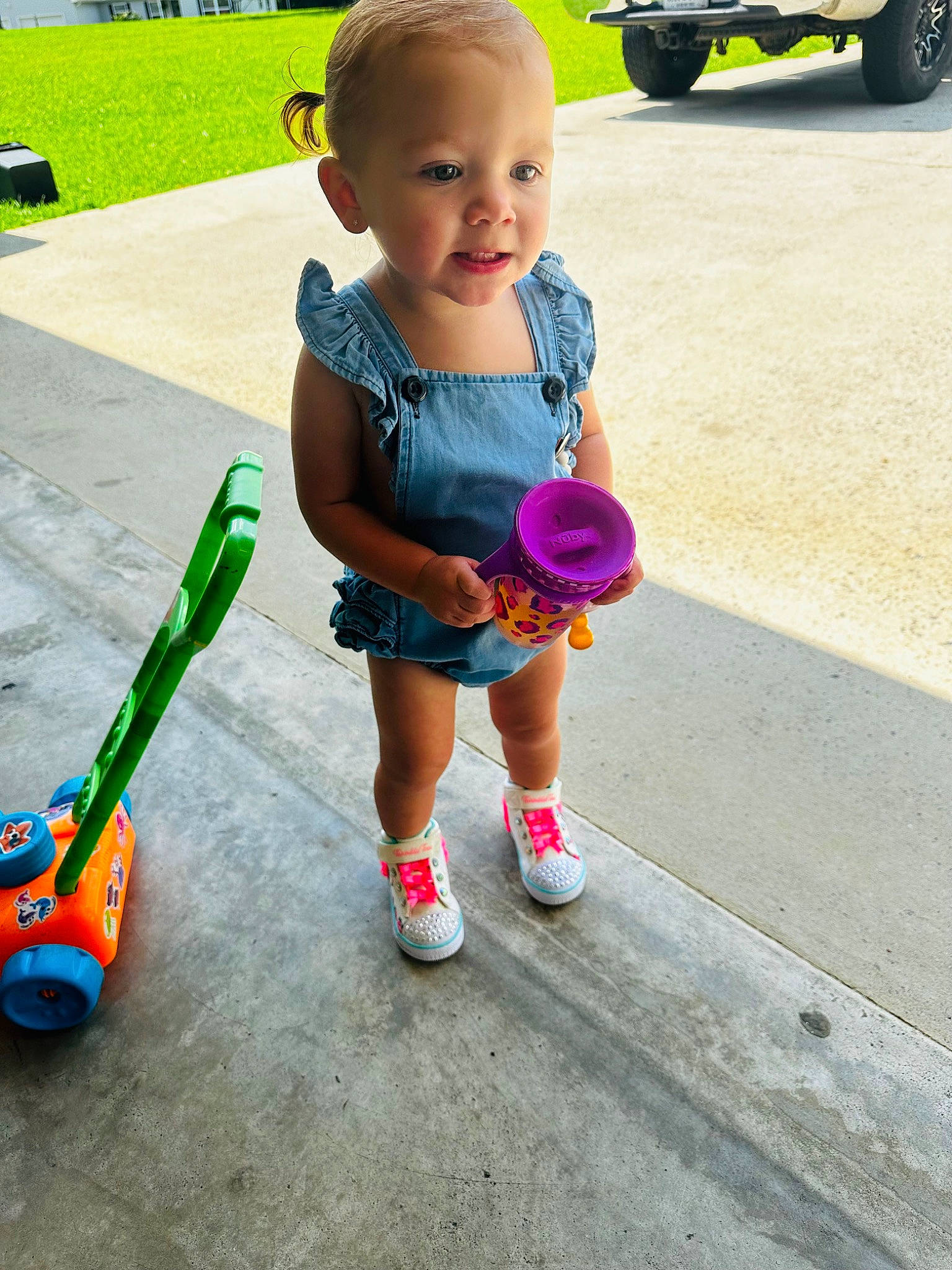 Presleigh is registered to the contest to win money with this photo: asphalt, automotive_tire, baby, baby_toddler_clothing, child, fun, grass, leisure, person, recreation, shoe, shorts, smile, snapshot, sneakers, thigh, tire, toddler, toy, wheel