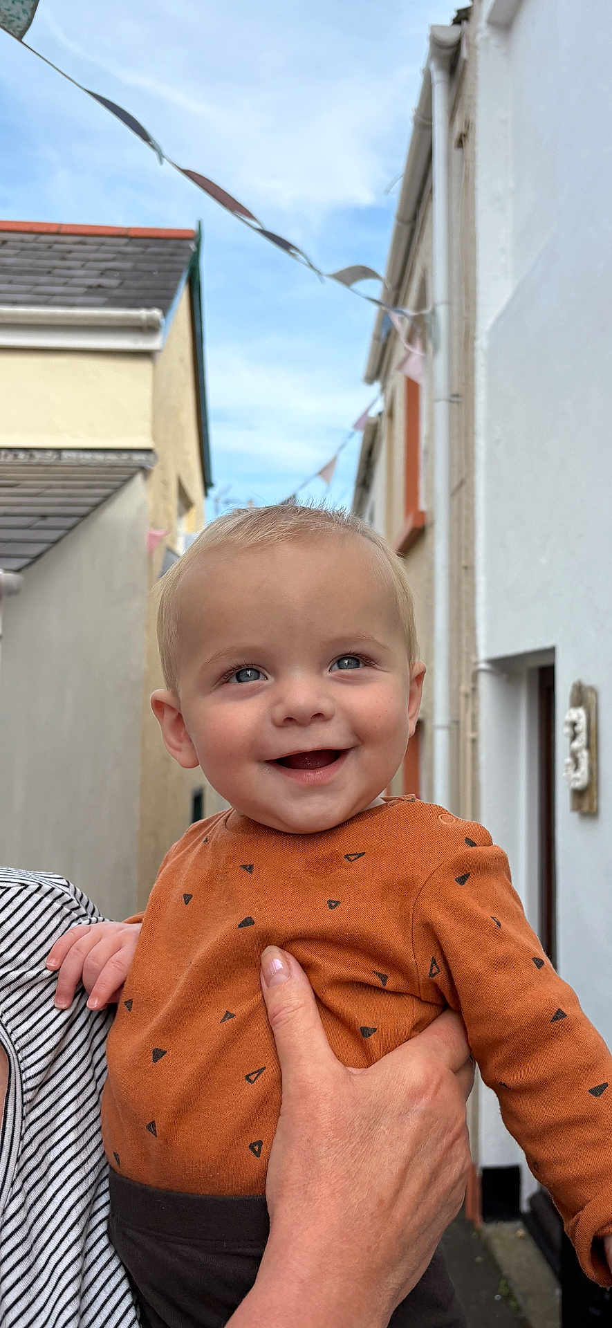 Alex joined the competition — help win amazing prizes! baby, child, smiling, happy, person, outdoor, sky, building, hand, clothing, holding, face, head, blue_eyes, casual_wear, infant, street, daylight, cute, portrait