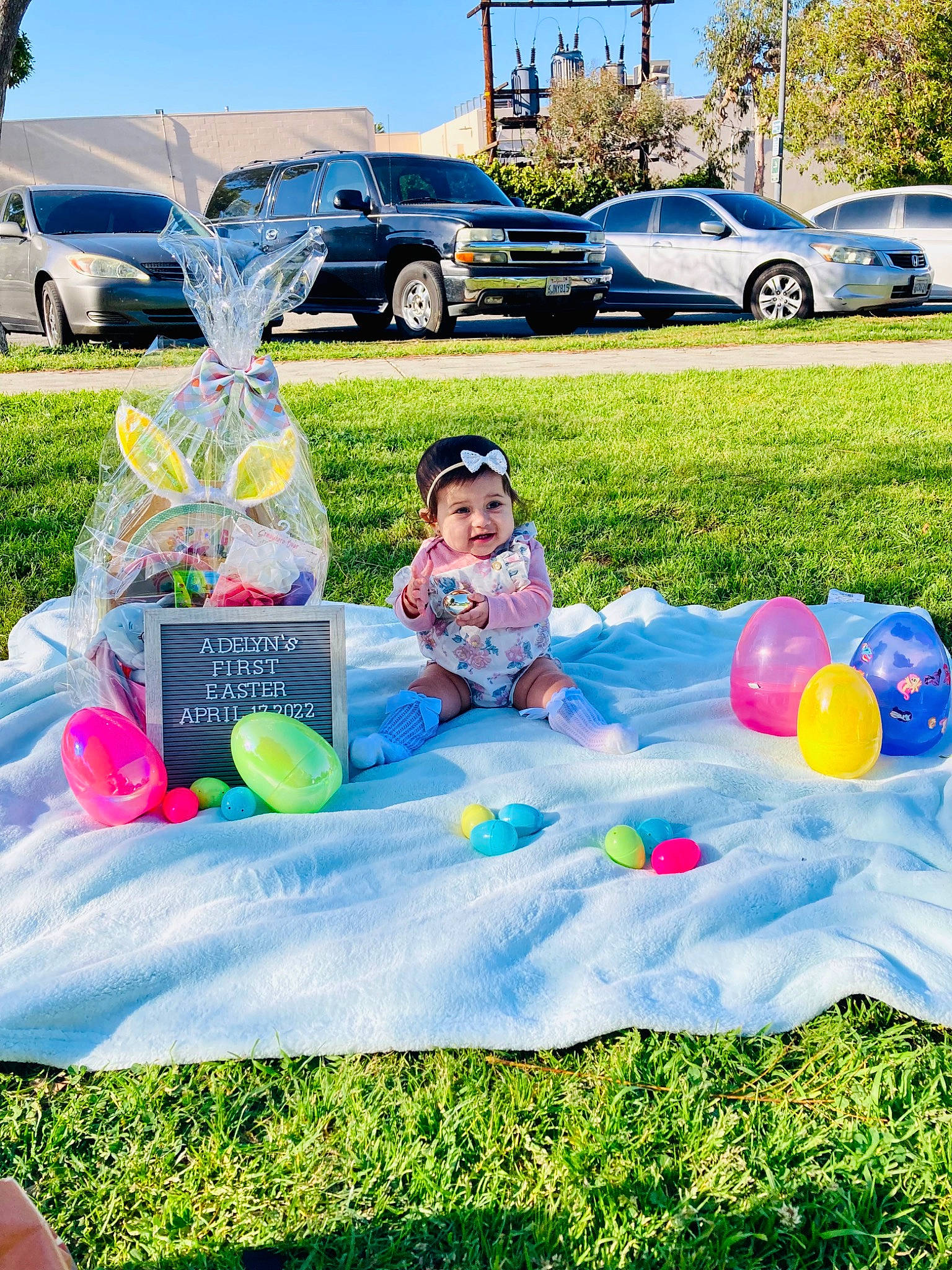 Adelyn joined the competition — help win amazing prizes! blue, car, dress, grass, hat, headwear, land_vehicle, lawn, leisure, mammal, party_supply, person, plant, public_space, recreation, sky, summer, tire, toddler, tree