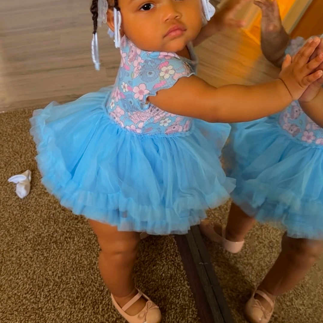 Sanaira is registered to the contest to win money with this photo: child, clothing, costume, dancing, dress, face, female, footwear, girl, happy, head, leisureactivities, person, photography, portrait, sandal, shoe, sitting, skirt, wood