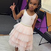 Skylah joined the competition — help win amazing prizes! child, girl, dress, peace_sign, pose, indoor, floor, window, blinds, chair, black_chair, marble_floor, white_socks, gold_shoes, necklace, hair_bows, braided_hair, colorful_wall, smiling, playful