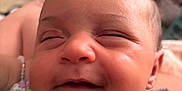 Imani joined the competition — help win amazing prizes! baby, child, closeup, cute, expression, face, floral_clothing, happy, head, human, indoors, infant, newborn, peaceful, person, portrait, skin, sleepy, smiling, soft_light