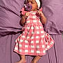 Imani joined the competition — help win amazing prizes! baby, infant, pacifier, headband, pink_dress, checkered_pattern, purple_bedspread, lying_down, clenched_fists, bare_feet, sleepwear, cute, newborn, child, bed, fabric, soft, adorable, portrait, indoor