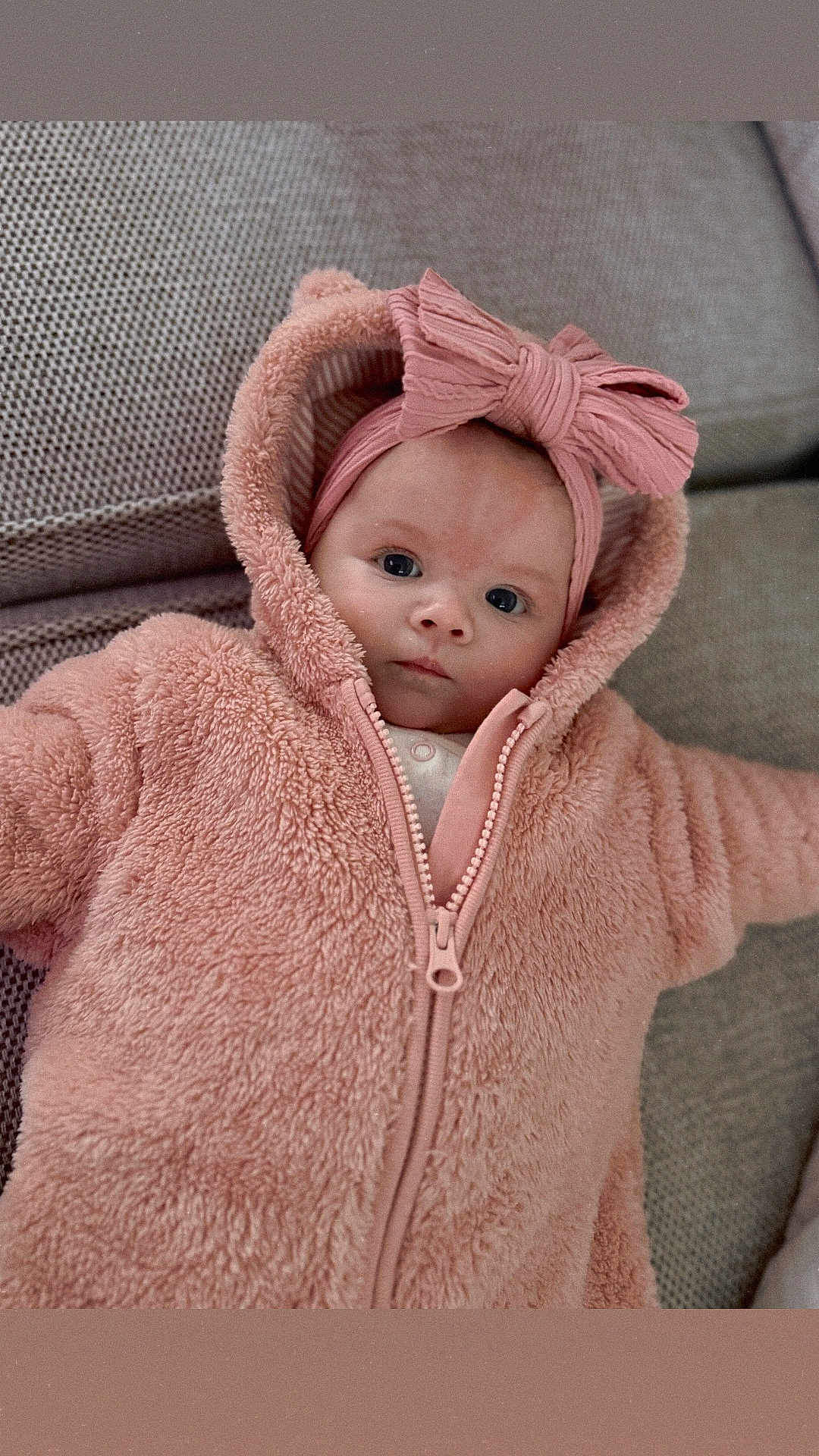 Josie joined the competition — help win amazing prizes! baby, infant, hoodie, pink, bow, headband, face, eyes, couch, fabric, texture, zipper, clothing, cute, child, portrait, indoor, soft, warm, cozy