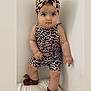 Eden participe au concours pour gagner de l'argent avec cette photo : adorable, baby, brown_booties, child, clothing, corner, cute, fashion, footwear, headwear, indoor, infant, leopard_print, looking_at_camera, one_person, portrait, standing, turban, white_wall, young_child