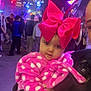 adult, baby, child, colorful, crowd, event, face, festive, hand, holding, jacket, lights, night, outdoor, people, pink_bow, polka_dot, portrait, urban, warm_clothing