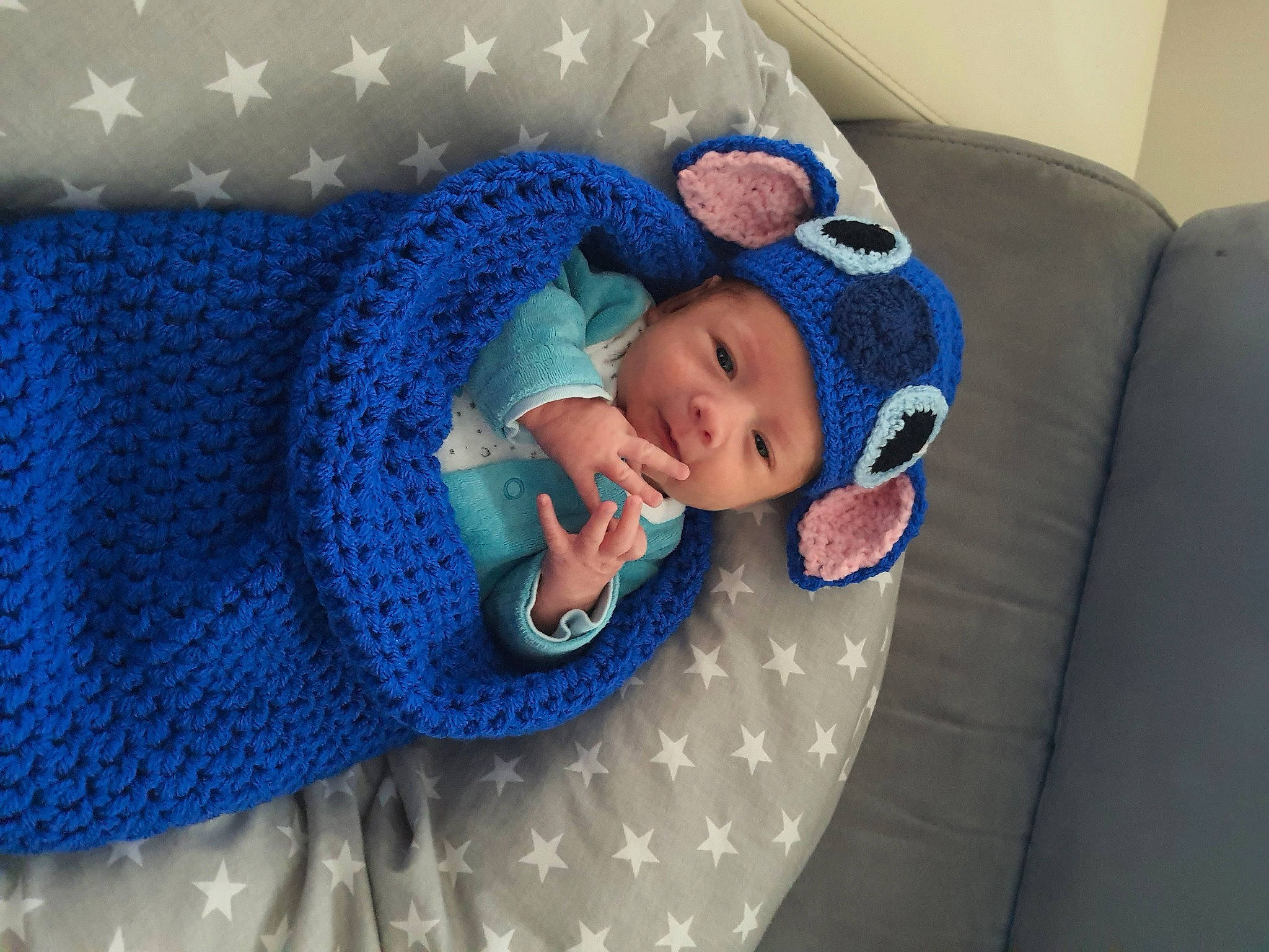 Liam participe au concours pour gagner de l'argent avec cette photo : azure, baby, baby_products, baby_sleeping, baby_toddler_clothing, beanie, child, comfort, craft, electric_blue, fashion_accessory, headwear, knit_cap, linens, pattern, person, purple, room, sleeve, textile