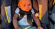 Sekai is registered to the contest to win money with this photo: baby, car_seat, infant, child, pacifier, clothing, seatbelt, sunlight, shadow, green_socks, white_shirt, blue_pants, safety, portrait, young_child, cute, indoors, fabric, straps, comfort