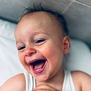 Roman participe au concours pour gagner de l'argent avec cette photo : toddler, child, smiling, laughing, face, closeup, happy, skin, hand, white_shirt, indoors, pillow, head, expression, joy, person, cute, baby, portrait, light