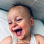 toddler, child, smiling, laughing, face, closeup, happy, skin, hand, white_shirt, indoors, pillow, head, expression, joy, person, cute, baby, portrait, light