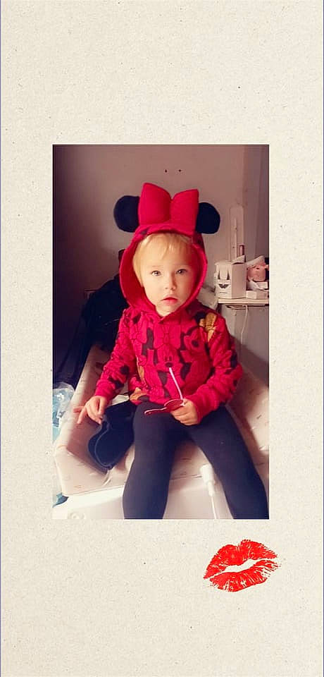 Eden a rejoint le concours — aidez-le/la à gagner de superbes lots ! baby, baby_toddler_clothing, carmine, child, collar, costume_hat, fashion_accessory, font, fur, happy, hood, magenta, outerwear, pattern, person, pink, red, sitting, sleeve, t_shirt