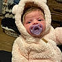 baby, pacifier, onesie, fluffy, bear_ears, infant, clothing, face, indoor, cute, portrait, child, young, warm, soft_texture, person, looking, expression, hood, cozy
