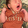 baby, infant, yawning, onesie, clothing, patterned_cushion, animal_print, sleepy, cute, child, newborn, soft_skin, hand, face, mouth_open, lying_down, toddler, indoor, portrait, expression