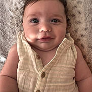 Silas is registered to the contest to win money with this photo: baby, blanket, button, child, closeup, clothing, cute, expression, eyes, face, hair, infant, lying_down, person, portrait, skin, smile, soft, texture, young