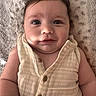 baby, blanket, button, child, closeup, clothing, cute, expression, eyes, face, hair, infant, lying_down, person, portrait, skin, smile, soft, texture, young