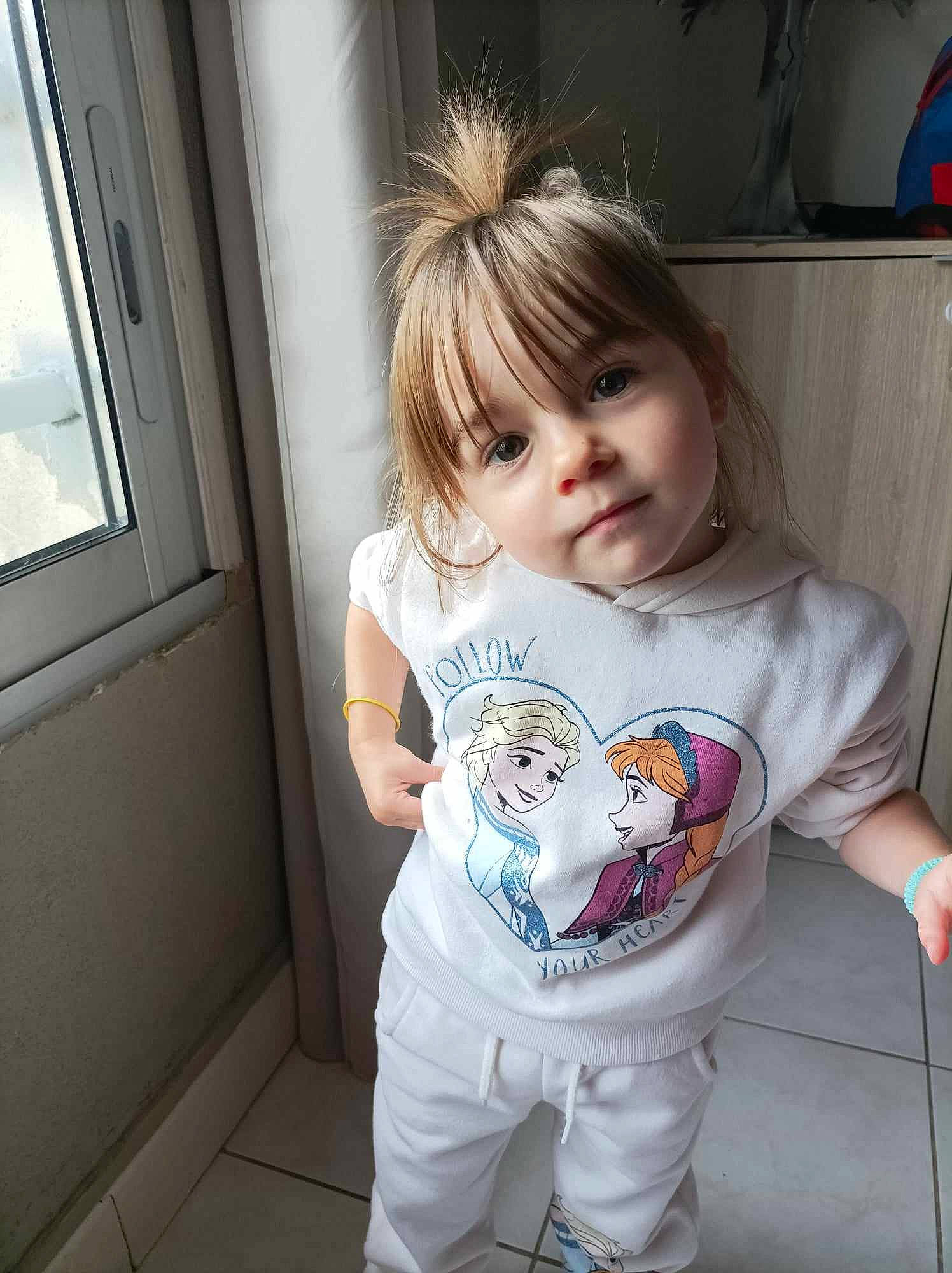 Judy a rejoint le concours — aidez-le/la à gagner de superbes lots ! baby_toddler_clothing, cheek, child, chin, cool, face, facial_expression, fun, happy, iris, joint, mammal, person, shoulder, skin, sleeve, standing, t_shirt, toddler, white