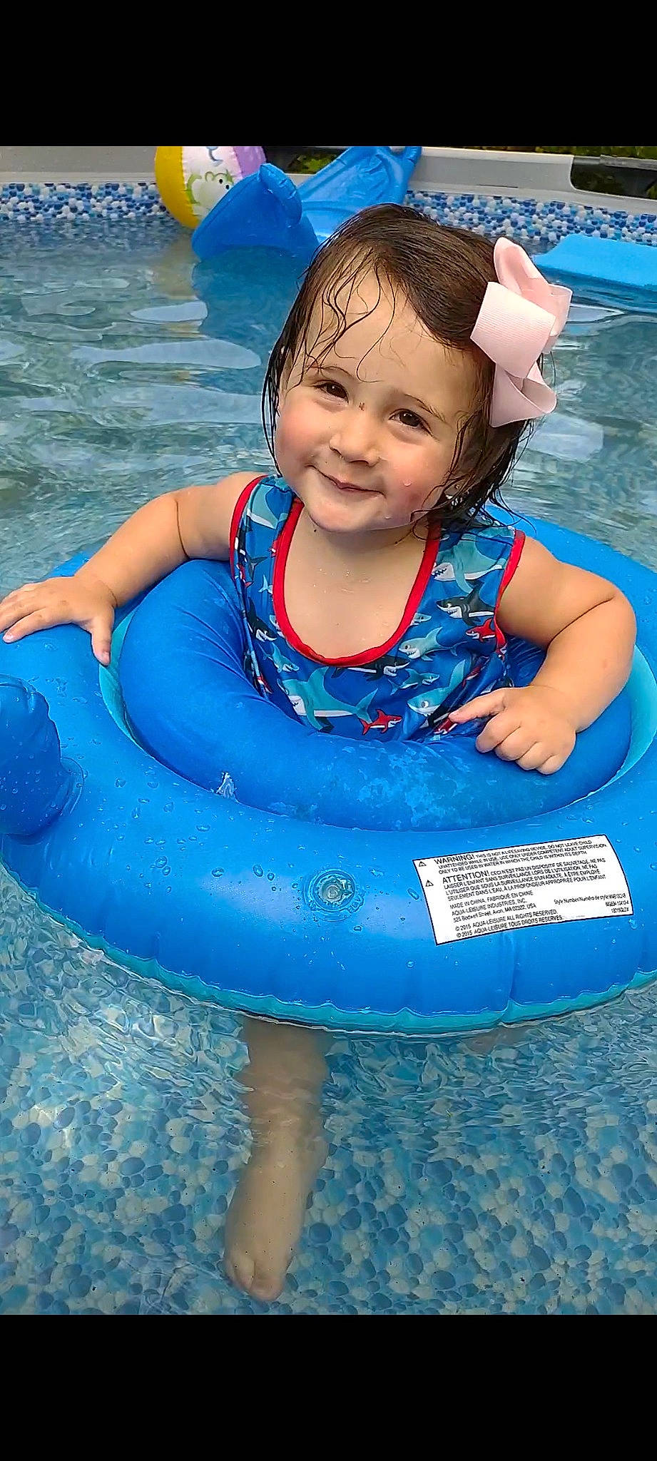 Belle is registered to the contest to win money with this photo: aqua, azure, baby, baby_float, baby_toddler_clothing, bathing, blue, electric_blue, fun, games, happy, joy, leisure, person, photograph, pink, product, recreation, smile, toddler