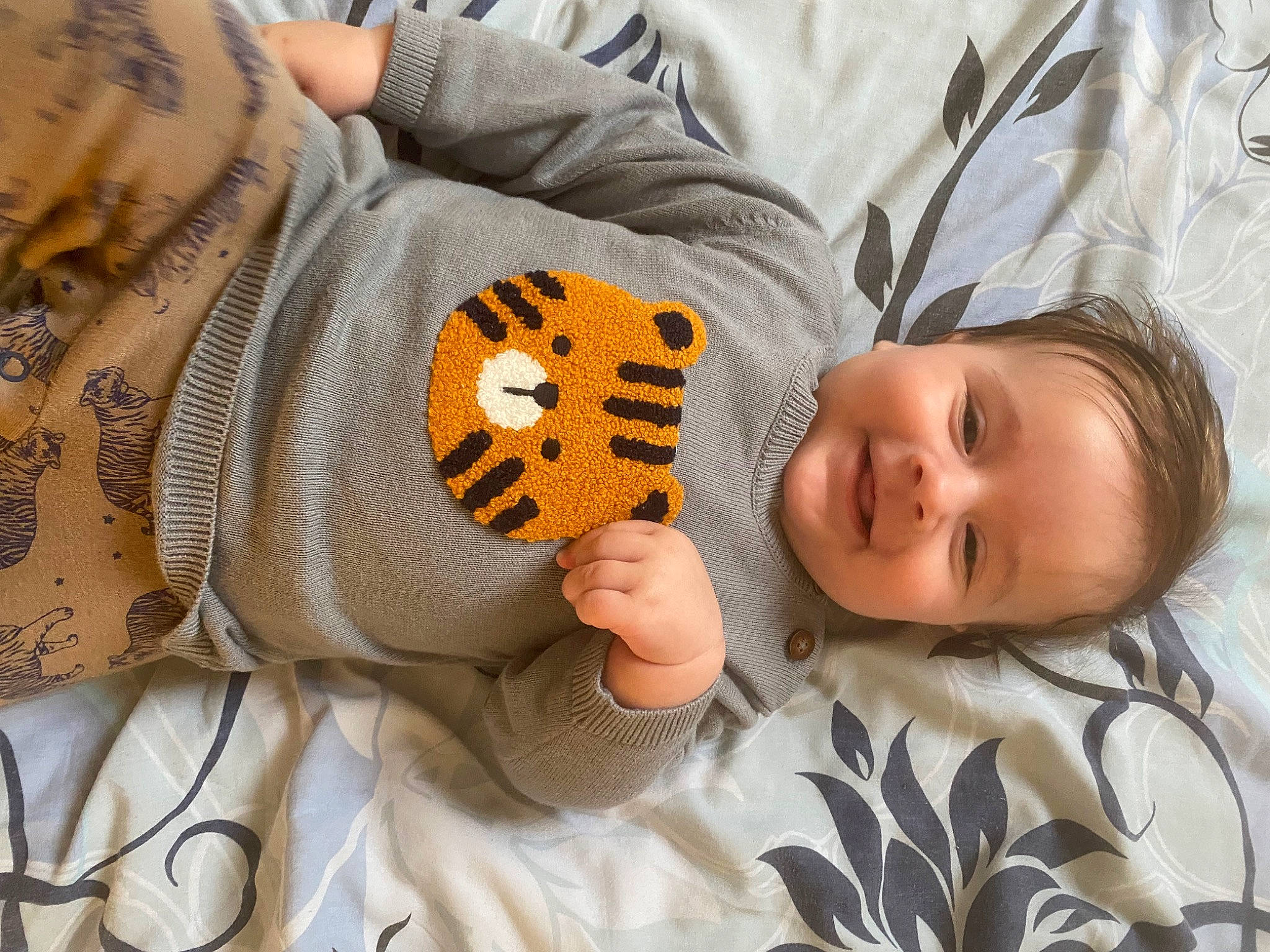 Léo a rejoint le concours — aidez-le/la à gagner de superbes lots ! baby, baby_sleeping, baby_toddler_clothing, bedding, bedtime, child, comfort, elbow, finger, happy, joy, linens, mammal, mouth, pattern, person, room, sleeve, smile, stuffed_toy