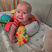 Vincent joined the competition — help win amazing prizes! baby, child, smiling, crib, pillow, plush_toy, colorful, polka_dots, elephant_pattern, bedding, infant, happy, cute, indoors, person, toy, orange_clothing, head, face, arm