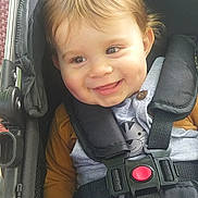 Nino a rejoint le concours — aidez-le/la à gagner de superbes lots ! baby, child, stroller, smile, face, straps, clothing, seatbelt, cute, happy, infant, hand, hair, button, fabric, child_seat, safety, portrait, closeup, young