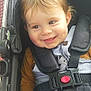 baby, child, stroller, smile, face, straps, clothing, seatbelt, cute, happy, infant, hand, hair, button, fabric, child_seat, safety, portrait, closeup, young