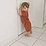 toddler, child, indoor, white_wall, door, tile_floor, barefoot, clothing, motion_blur, young_child, person, standing, brown_hair, shorts, tshirt, home, casual, leaning, light, minimalist