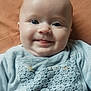 baby, smile, face, blue_eyes, tongue, clothing, texture, closeup, infant, cute, child, portrait, laying_down, soft_light, indoors, happy, young_child, head, person, skin