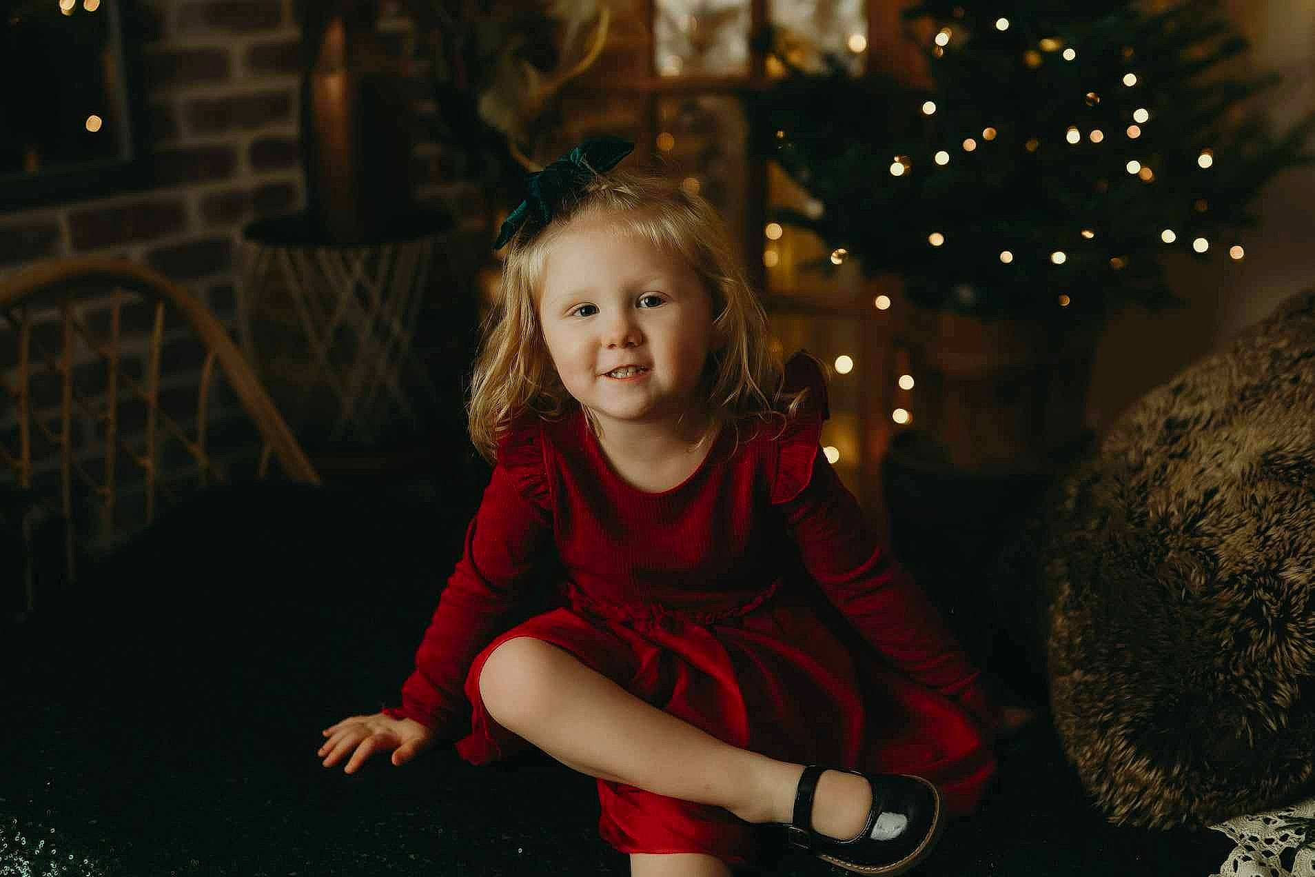 Haven is registered to the contest to win money with this photo: black, blond, child, christmas_decoration, christmas_ornament, christmas_tree, event, flash_photography, fun, grass, hairstyle, happy, head, holiday, person, plant, sitting, standing, toddler, tree