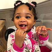 Malani is registered to the contest to win money with this photo: baby, chair, child, close_up, curly_hair, family_photo, floral_outfit, girl, hair_bows, happy, high_chair, indoor, kitchen, pink_clothing, portrait, reaching, sitting, smiling, teeth, toddler