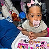 Malani is registered to the contest to win money with this photo: baby, baby_clothes, bottles, child, close_up, colorful, curly_hair, hair_bows, high_chair, home, indoor, infant, minnie_mouse, pacifier, playful, portrait, seated, smiling, stuffed_animal, toys