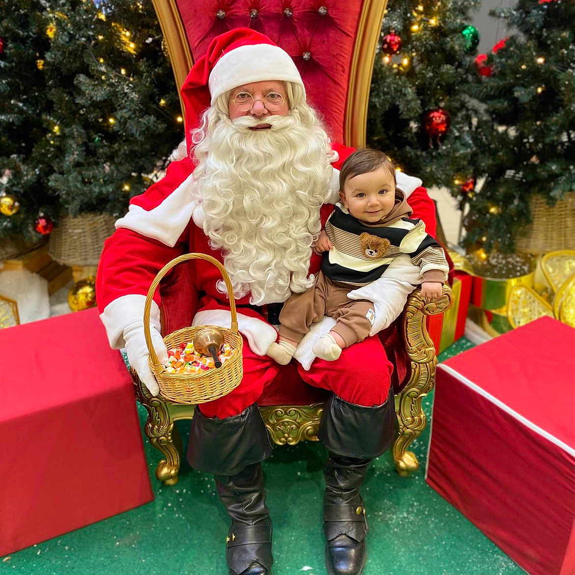Ayden a rejoint le concours — aidez-le/la à gagner de superbes lots ! baby, basket, candy, chair, child, christmas, decorations, festive, gift, glasses, green_floor, happy, holiday, indoor, lights, red_clothing, santa_claus, smile, tree, white_beard