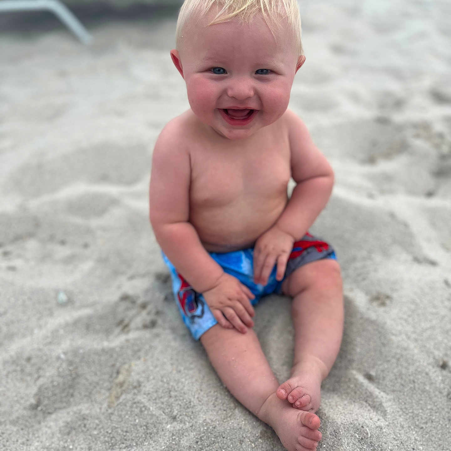 Noah joined the competition — help win amazing prizes! baby, beach, clothing, coast, face, happy, head, nature, outdoors, pants, person, photography, portrait, sea, shoreline, shorts, sitting, summer, swimwear, water