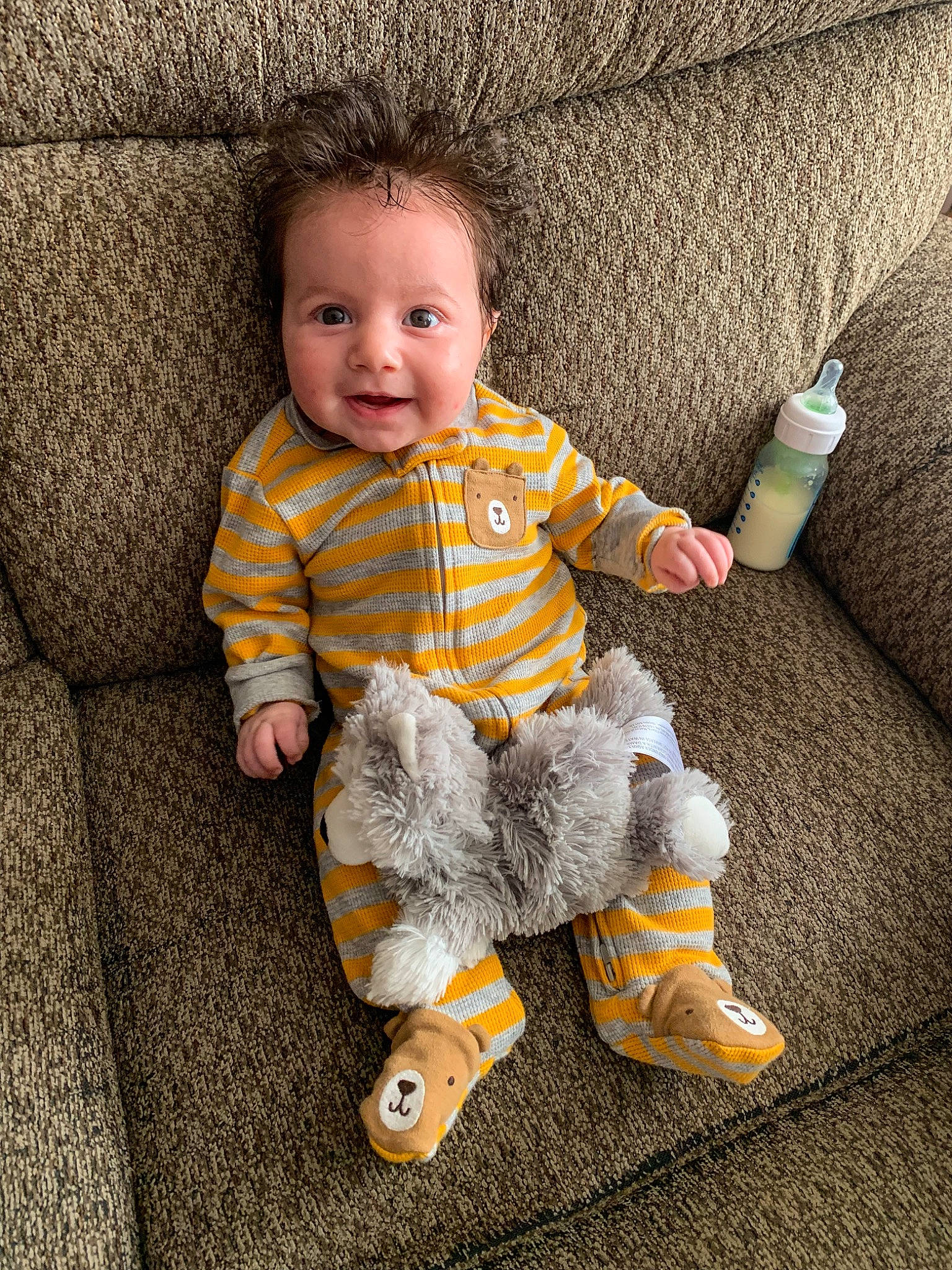 Cassius is registered to the contest to win money with this photo: baby, baby_toddler_clothing, cheek, child, comfort, face, flooring, happy, human_body, linens, outerwear, pattern, person, product, skin, sleeve, smile, t_shirt, textile, toddler