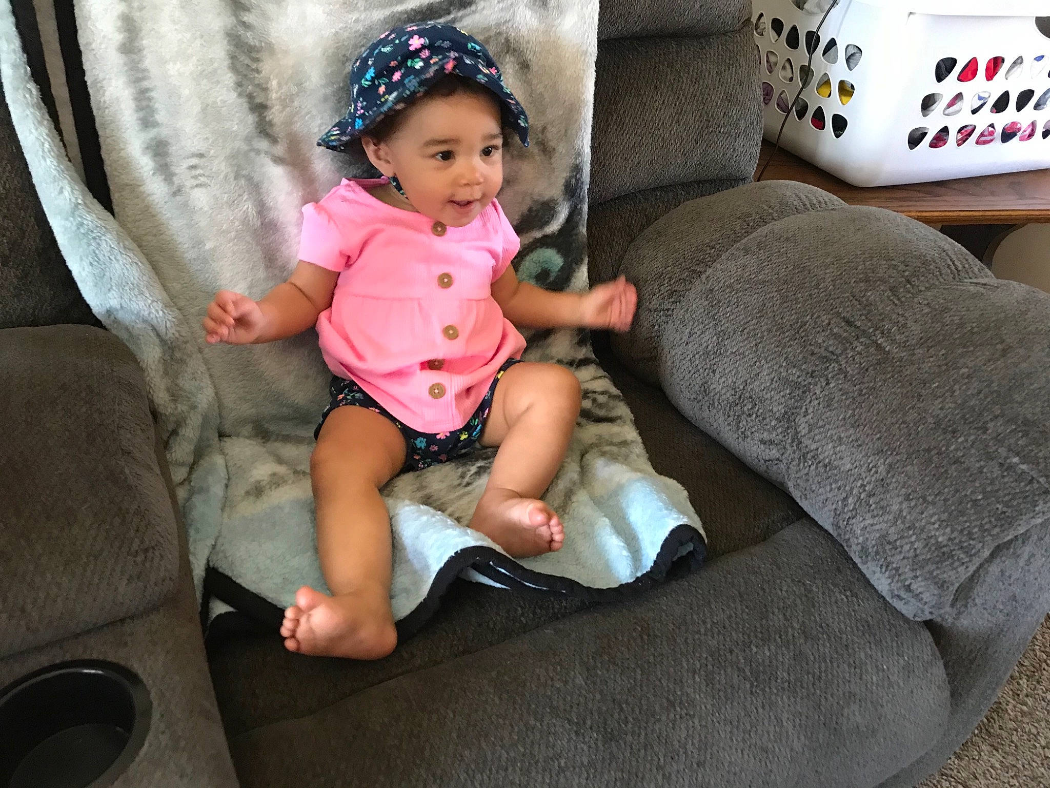 Ceaunna is registered to the contest to win money with this photo: baby, baby_toddler_clothing, cap, comfort, couch, curtain, fashion_accessory, fun, headgear, human_leg, lap, leg, linens, person, pillow, pink, sitting, sock, thigh, throw_pillow