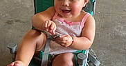 Hailey joined the competition — help win amazing prizes! child, toddler, girl, smiling, sitting, chair, outdoor, garage, concrete_floor, barefoot, pink_clothing, ponytail, portrait, happy, playful, toy, scooter, cooler, household_items, casual_photo