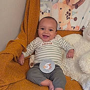 Isaac a rejoint le concours — aidez-le/la à gagner de superbes lots ! baby, smiling, infant, striped_shirt, gray_pants, orange_blanket, animal_blanket, milestone_card, happy, indoor, soft_toys, cozy, child, cute, sitting, face, head, young_child, person, portrait