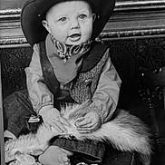 Ranger joined the competition — help win amazing prizes! baby, child, cowboy_hat, vintage, black_and_white, portrait, sitting, costume, western, hat, vest, shirt, scarf, fur_blanket, chair, furniture, indoors, looking_at_camera, face, photography