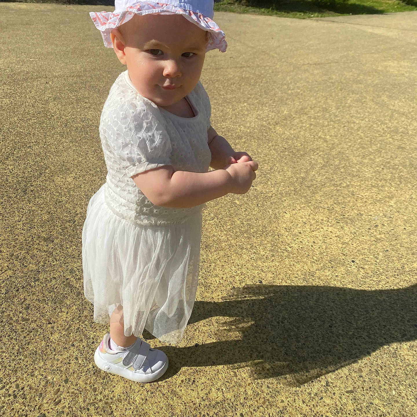 Jolyne participe au concours pour gagner de l'argent avec cette photo : baby, bonnet, cap, clothing, dress, face, footwear, grass, hat, head, person, photography, plant, portrait, sandal, shoe, sneaker, soil, sunhat, walking