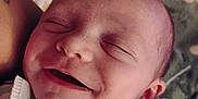 Amelia is registered to the contest to win money with this photo: baby, newborn, smile, sleeping, closeup, face, dimple, blanket, striped, infant, peaceful, resting, soft, skin, head, person, child, wrapped, indoors, comfort