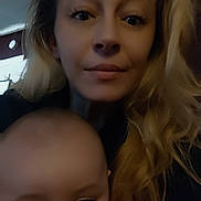 Amelia is registered to the contest to win money with this photo: woman, baby, selfie, portrait, indoor, blond_hair, long_hair, child, face, eyes, baby_face, mother_and_child, closeup, low_light, casual, cuddling, skin, expression, home_interior, blur