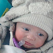 Amelia is registered to the contest to win money with this photo: baby, blanket, blue_eyes, child, closeup, cold_weather_clothing, cozy, cute, face, hooded_jacket, indoors, infant, knitted_hat, pacifier, portrait, small_person, snug, soft_texture, warm, winter