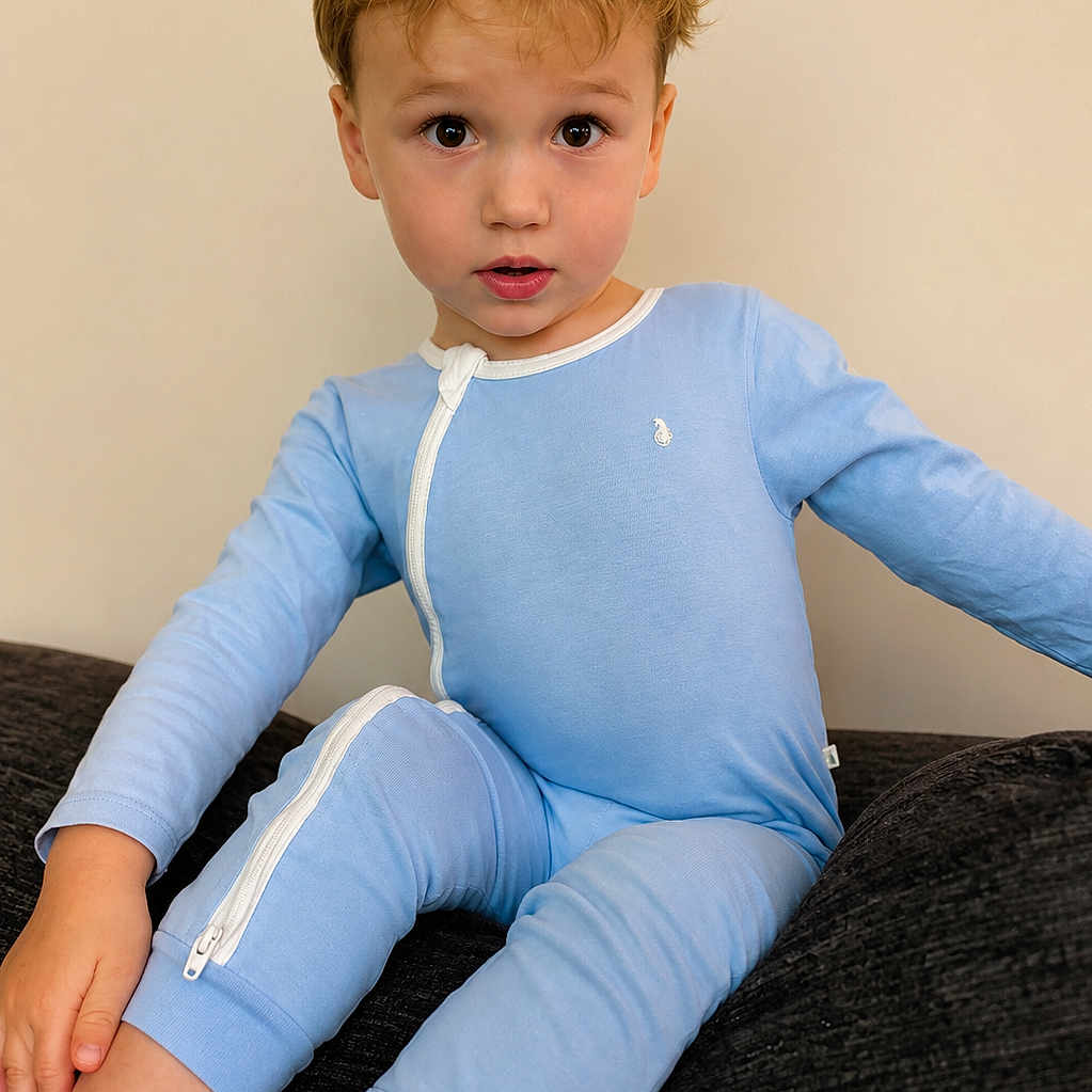 саймон is registered to the contest to win money with this photo: child, toddler, blue_onesie, blonde_hair, curious_expression, sitting, indoor, couch, cozy, portrait, young_child, casual_clothing, zipper, comfortable, looking_at_camera, cute, innocent, light_background, home, relaxed