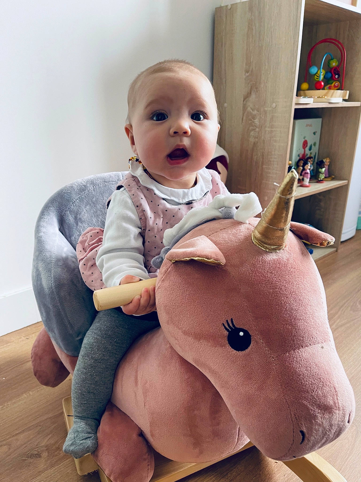 Maëlle participe au concours pour gagner de l'argent avec cette photo : baby, baby_toddler_clothing, cheek, chin, comfort, eye, face, facial_expression, gesture, happy, head, human_body, joint, leg, mouth, person, pink, shelf, skin, sleeve