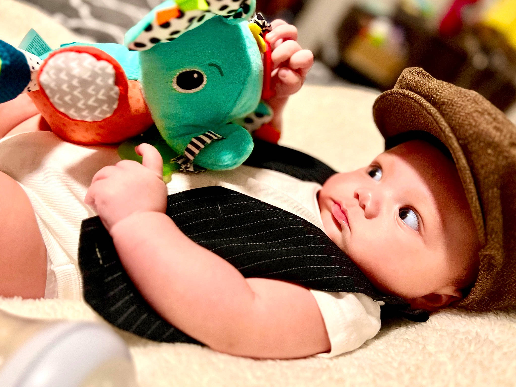 Ezekiel is registered to the contest to win money with this photo: baby, baby_products, baby_toddler_clothing, beanie, cap, child, comfort, fashion_accessory, finger, fun, happy, headwear, leisure, nail, pattern, person, plush, sitting, stuffed_toy, thigh
