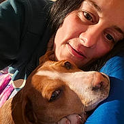 Babygirl is registered to the contest to win money with this photo: woman, person, dog, brown_dog, white_dog, pit_bull_type, pet, cuddle, selfie, portrait, face, eyes, smile, indoors, blanket, blue_clothing, warm_lighting, close_up, affection, companion