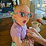 baby, child, sunglasses, pink, purple_shirt, table, hands, living_room, couch, lamp, toy, cup, window, sunlight, floor, person, expression, indoor, furniture, playing