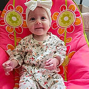 Delilah joined the competition — help win amazing prizes! baby, child, infant, smile, headband, floral_outfit, pink_chair, flower_pattern, cute, indoors, seated, happy, portrait, young_child, colorful, comfortable, clothing, person, baby_girl, headwear