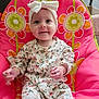 baby, child, infant, smile, headband, floral_outfit, pink_chair, flower_pattern, cute, indoors, seated, happy, portrait, young_child, colorful, comfortable, clothing, person, baby_girl, headwear