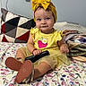 Isabella is registered to the contest to win money with this photo: baby, bed, bedroom, blanket, bow_headband, child, colorful, cute, dress, fashion, floral_bedspread, indoors, infant, pillow, portrait, shoes, sitting, smiling, toy_handle, yellow_outfit